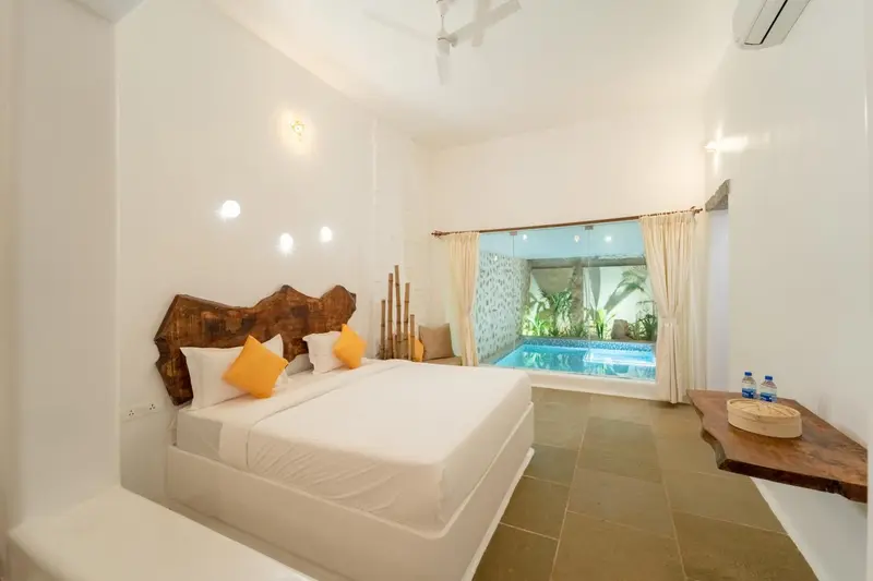 Une chambre lumineuse avec un lit double et un accès à une piscine extérieure.
