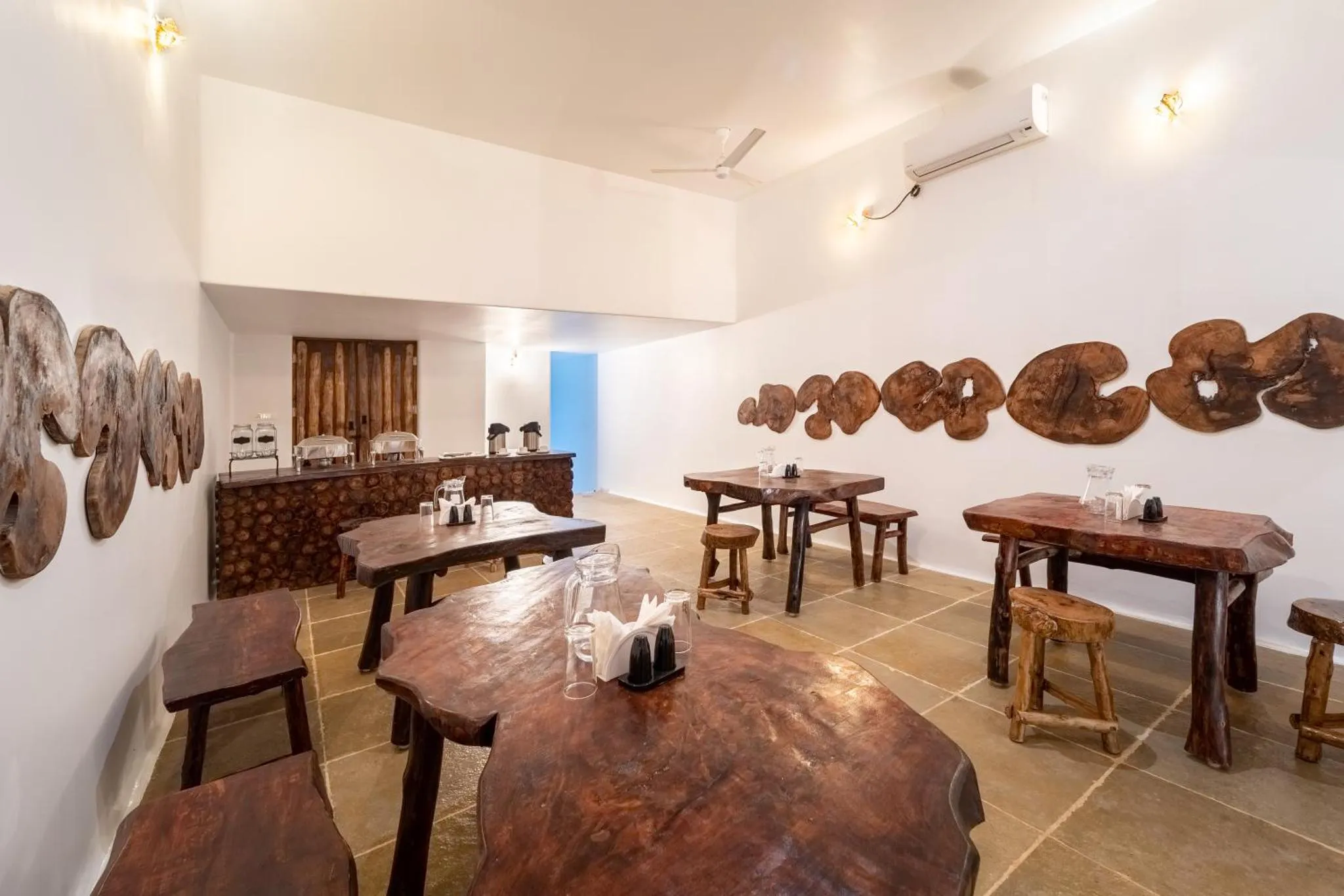 Une salle à manger lumineuse avec des tables en bois massif.