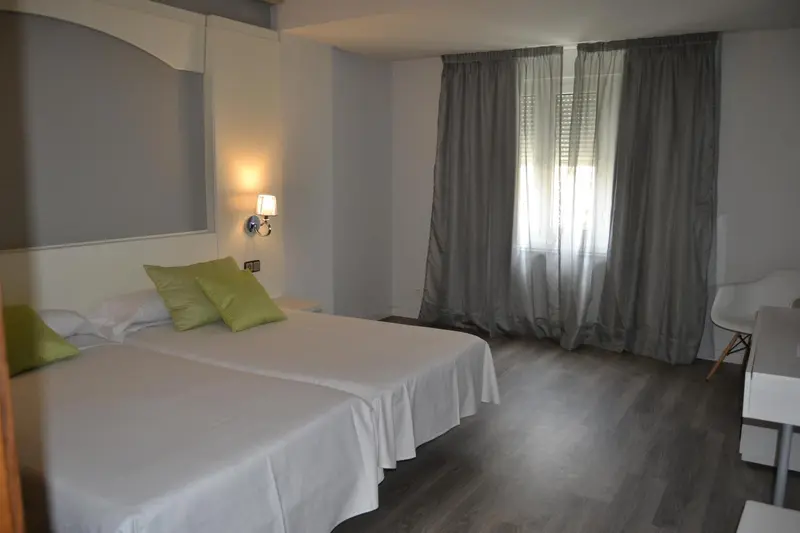 Une chambre lumineuse avec un grand lit et une chaise.