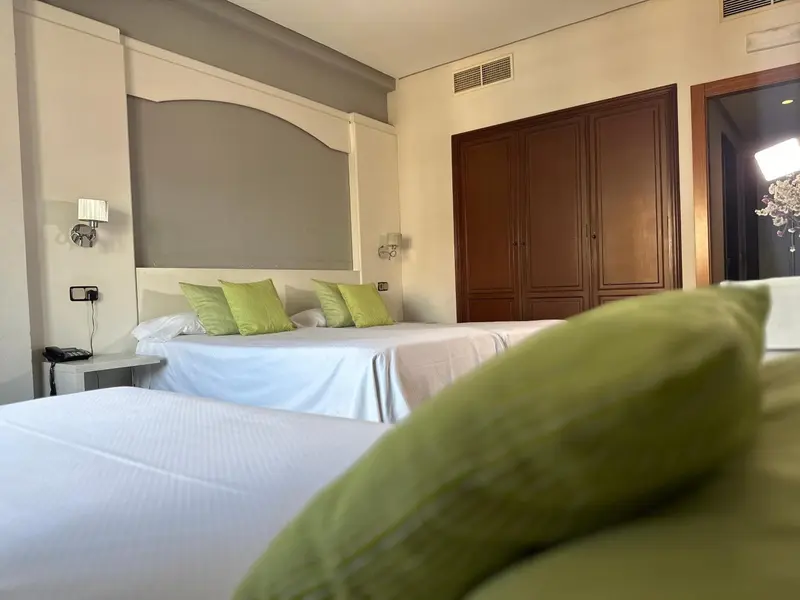 Une chambre lumineuse avec deux lits simples et une décoration sobre.
