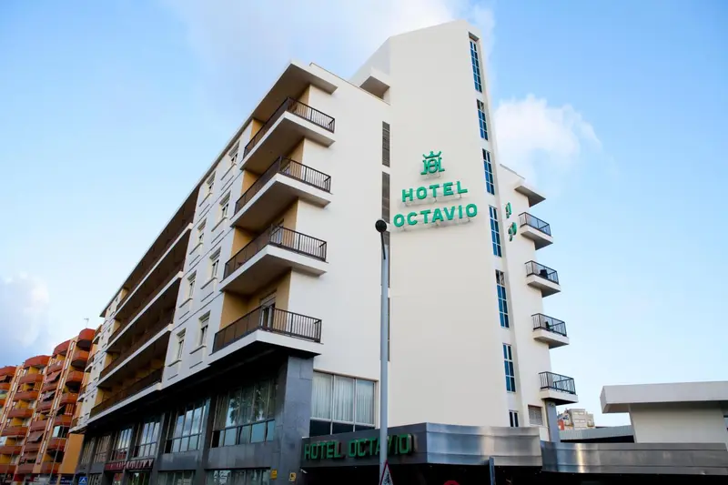 Façade d'un bâtiment blanc à plusieurs étages avec des balcons.