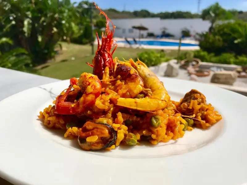 Assiette de paella garnie de fruits de mer et de légumes.