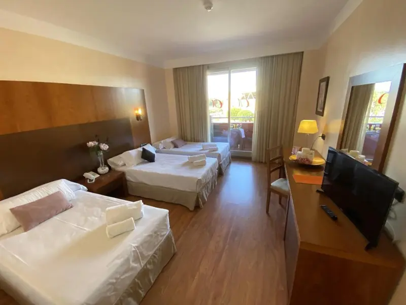Chambre lumineuse avec deux lits simples et une table de chevet.