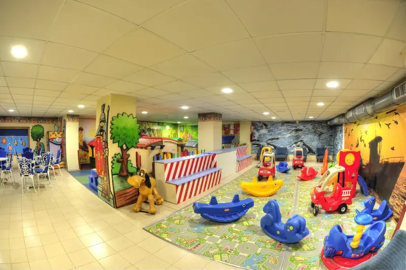 Espace de jeux coloré pour enfants avec structures et jouets.
