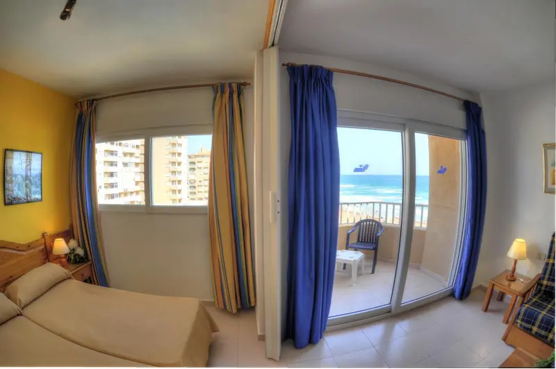 Chambre lumineuse avec vue sur la mer et balcon aménagé.