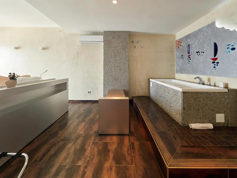 Une salle de bain spacieuse avec deux baignoires et un sol en bois sombre.