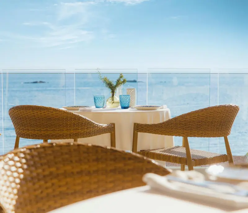 Table dressée en terrasse avec vue sur la mer.