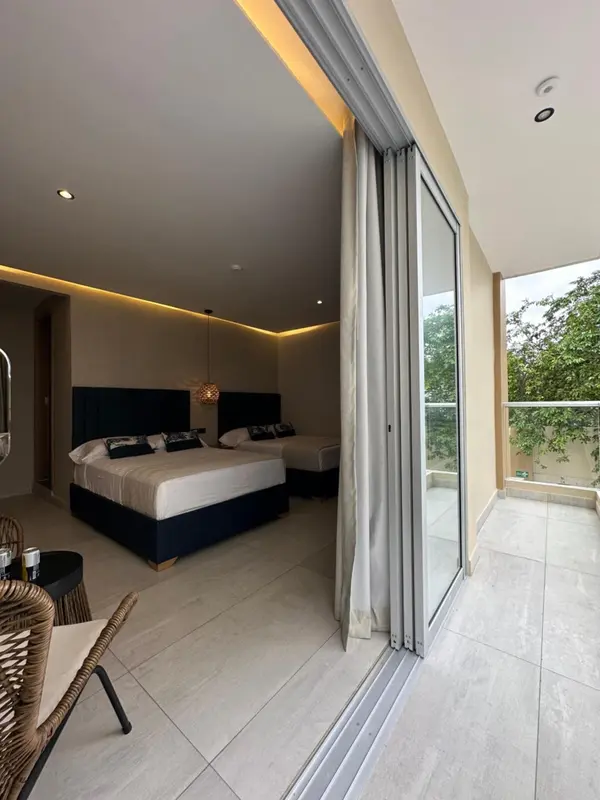 Chambre moderne avec un grand lit et un accès à une terrasse.