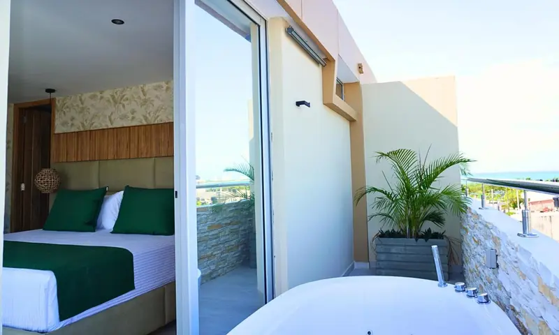 Une chambre lumineuse s'ouvre sur une terrasse avec jacuzzi.