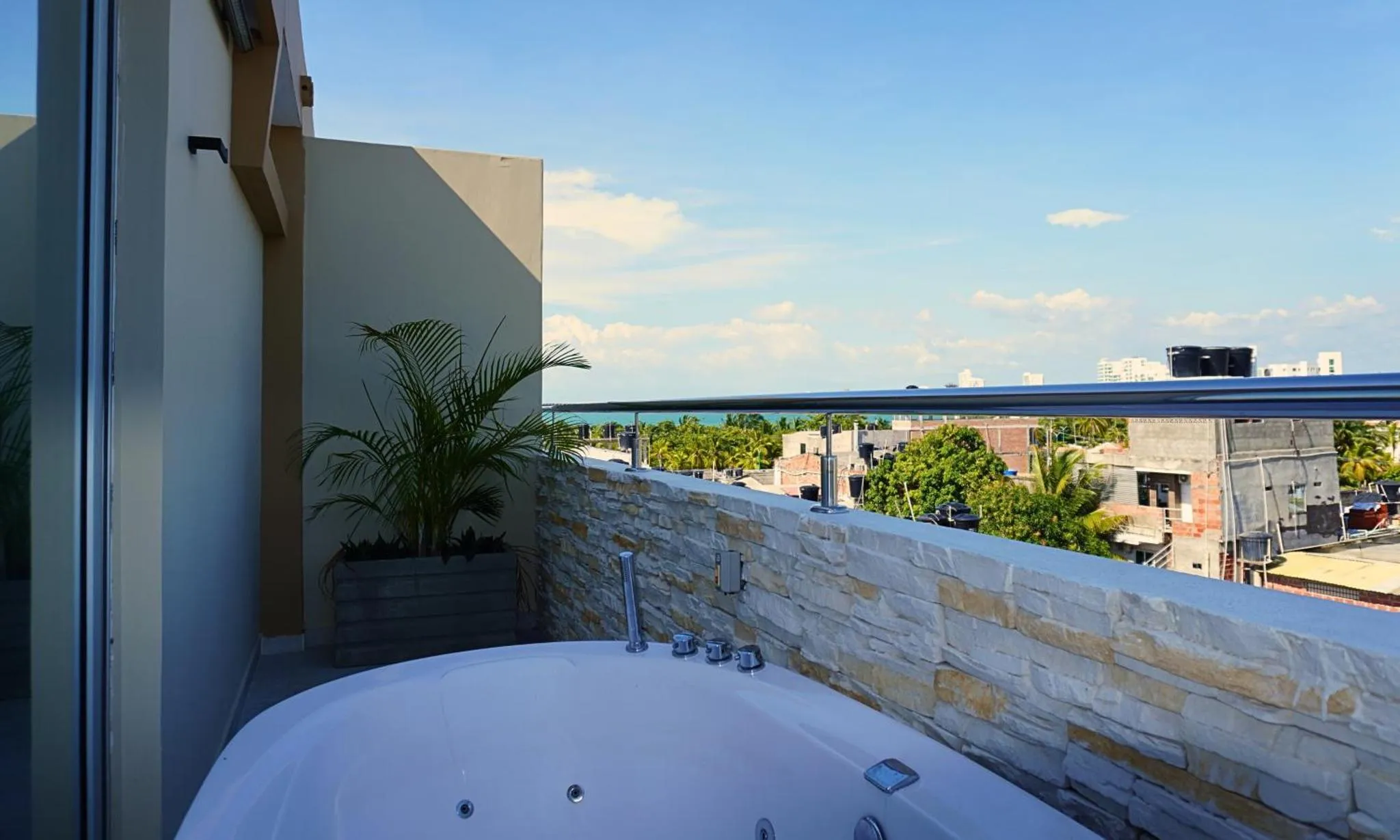 Une baignoire sur une terrasse avec vue sur la mer et la ville.