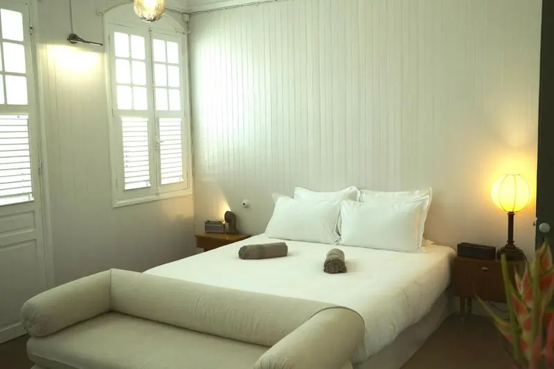 Une chambre lumineuse avec un grand lit et un canapé.