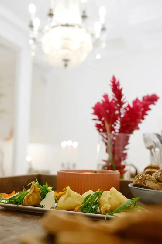 Une table est dressée avec des plats et des fleurs.