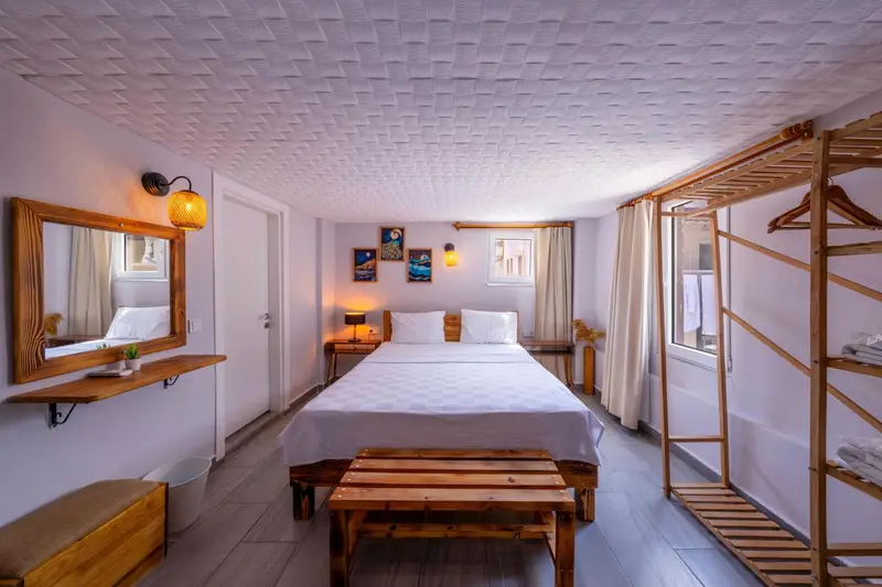 Une chambre lumineuse avec un lit double et un miroir décoratif.