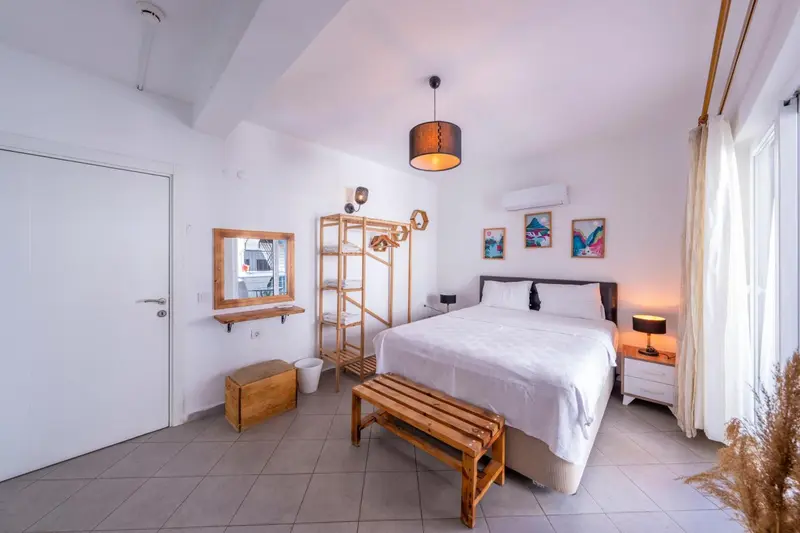 Une chambre lumineuse avec un lit double et une décoration minimaliste.