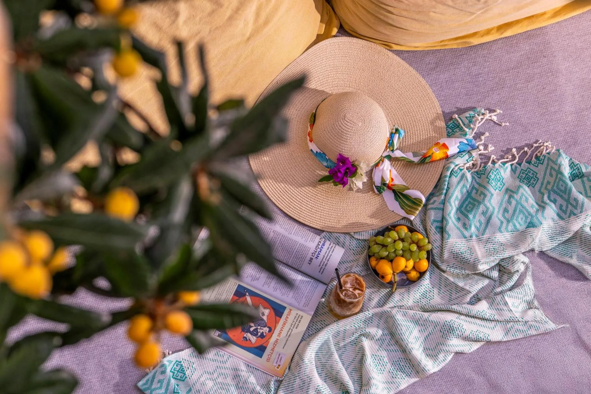 Nature morte estivale avec des chapeaux, des agrumes et une boisson.