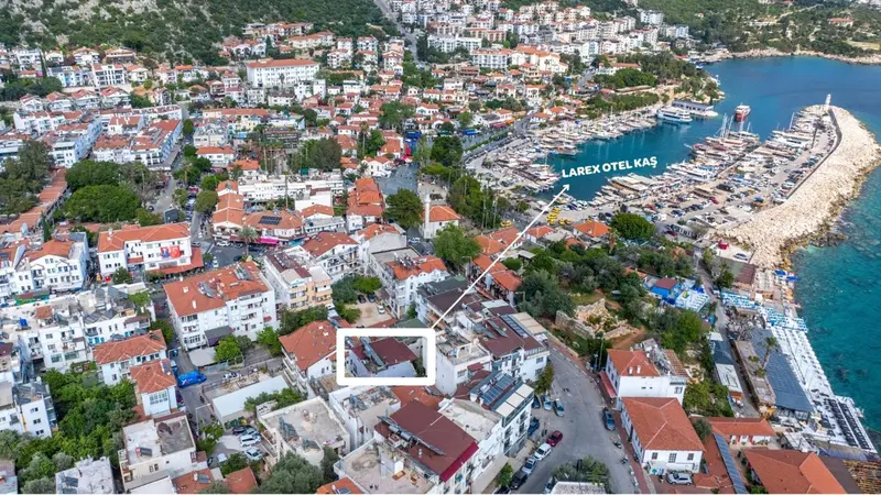 Vue aérienne d'une ville côtière avec des bâtiments blancs et une marina.