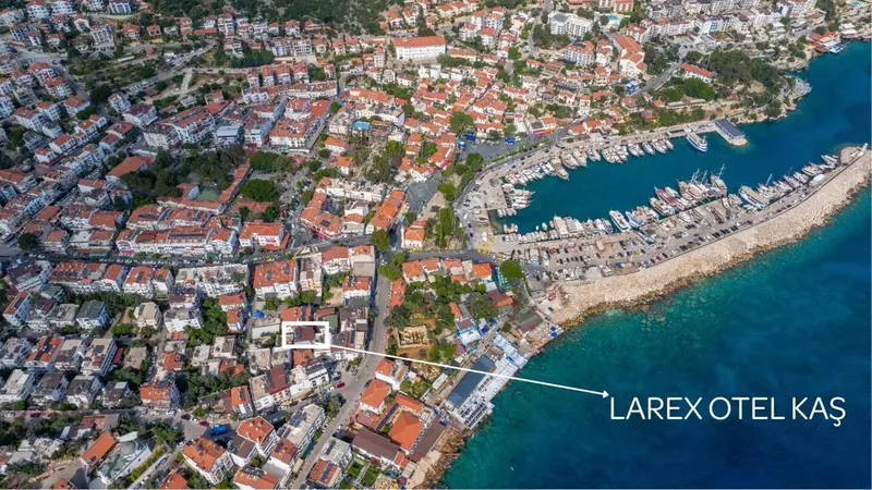 Vue aérienne d'une ville côtière avec des bâtiments aux toits rouges et une marina.