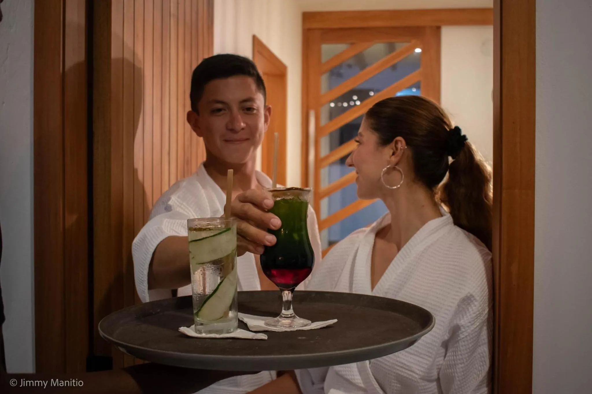 Un couple trinque avec des boissons fraîches dans un intérieur clair.
