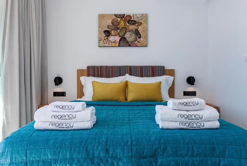 Un lit double est soigneusement fait avec des oreillers moelleux et des couvertures colorées.