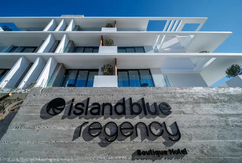 Façade moderne d'un bâtiment blanc avec une inscription au sol.