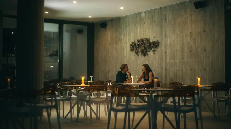 Une table est dressée dans une salle éclairée aux bougies.