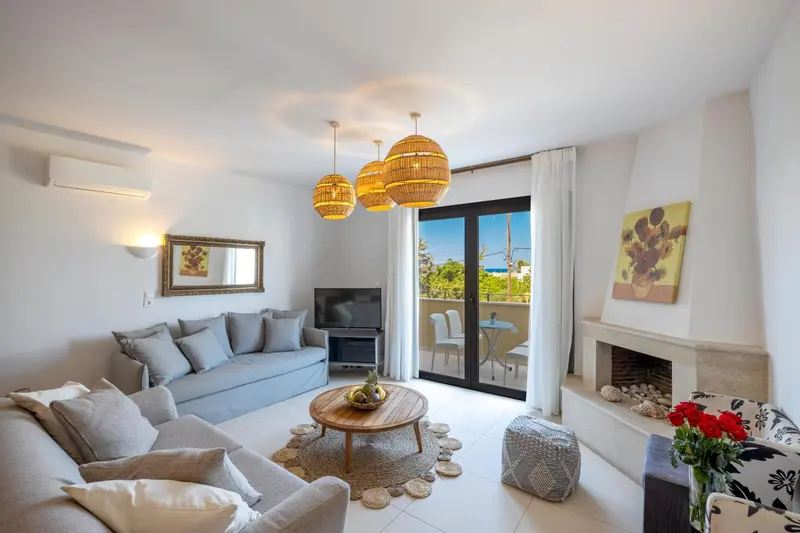 Espace de détente lumineux avec canapés et décoration florale.