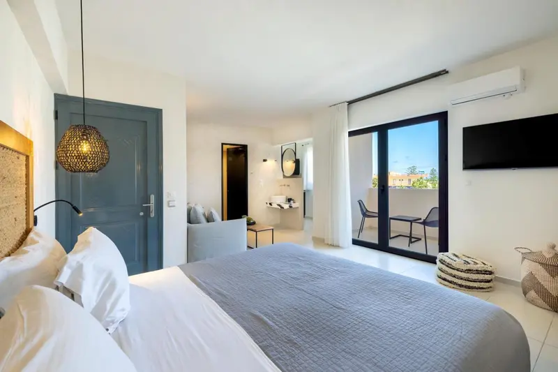Une chambre lumineuse avec un grand lit et un accès à une terrasse.