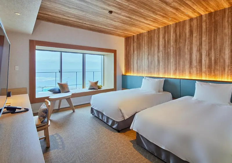 Chambre lumineuse avec vue sur la mer depuis une fenêtre en alcôve.