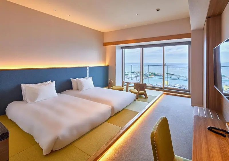 Une chambre lumineuse avec un grand lit et une vue sur la mer.