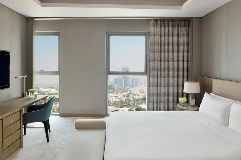 Chambre moderne avec un grand lit et une vue sur la ville.