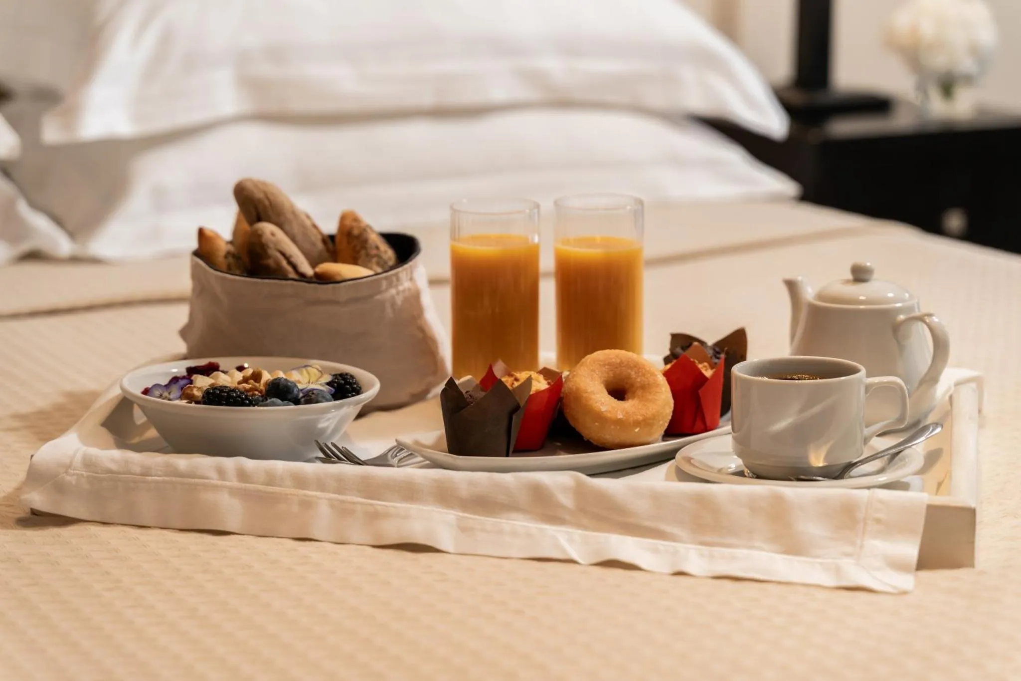 Un plateau de petit-déjeuner est posé sur un lit.