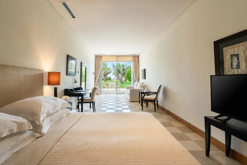 Une chambre lumineuse avec un grand lit et un accès à une terrasse.