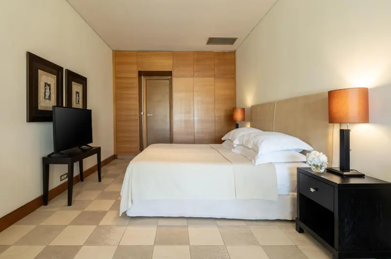 Une chambre lumineuse avec un grand lit et des tableaux décoratifs.