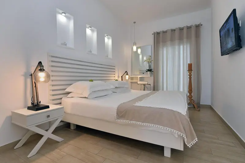 Une chambre lumineuse avec un grand lit et une décoration sobre.