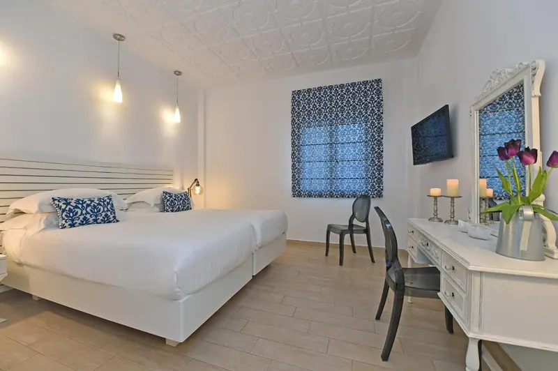 Une chambre lumineuse avec un grand lit et un bureau.