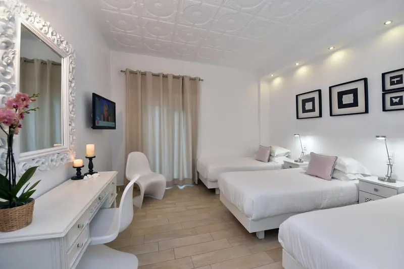 Une chambre lumineuse avec deux lits simples et un coin coiffeuse.
