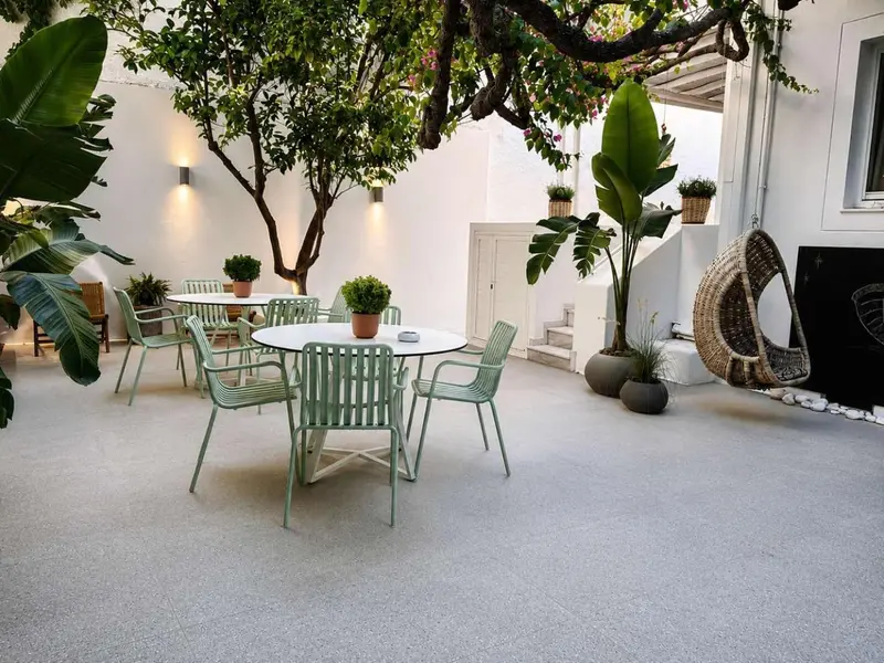 Une cour intérieure aménagée avec des tables et des chaises vertes.