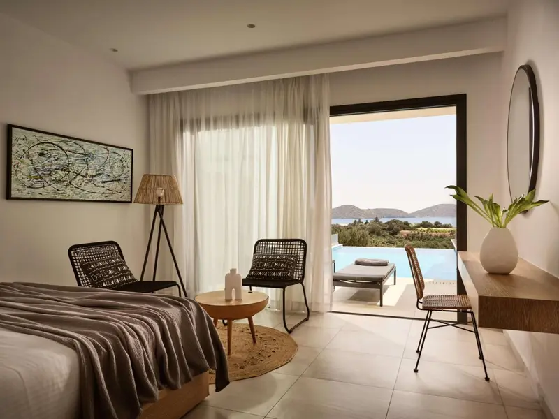 Une chambre lumineuse s'ouvre sur une terrasse avec vue sur la mer.