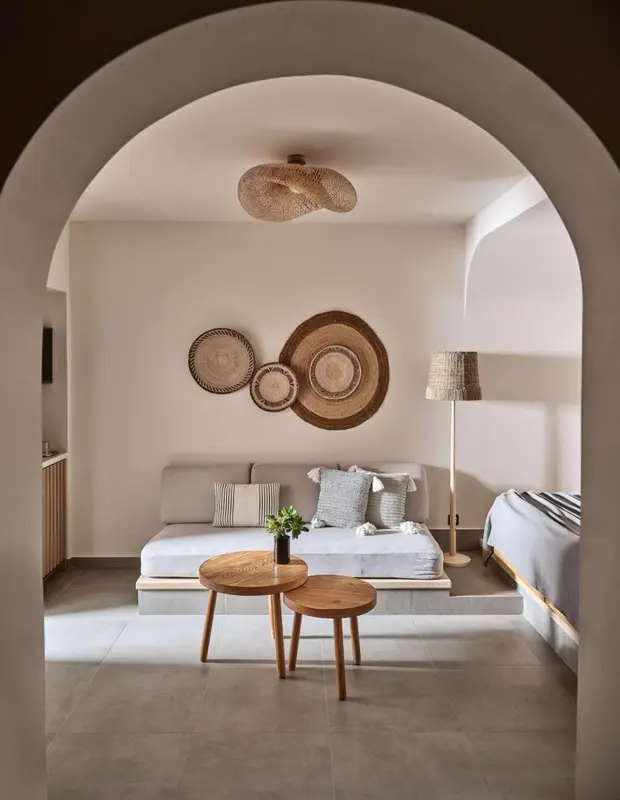 Une chambre lumineuse avec un canapé et des tables basses en bois.