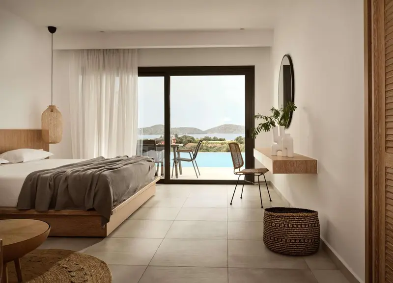 Une chambre lumineuse avec un grand lit et une vue sur la mer.