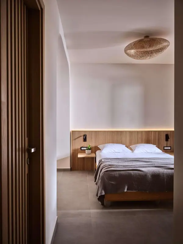 Une chambre lumineuse avec un lit double et une décoration en bois.