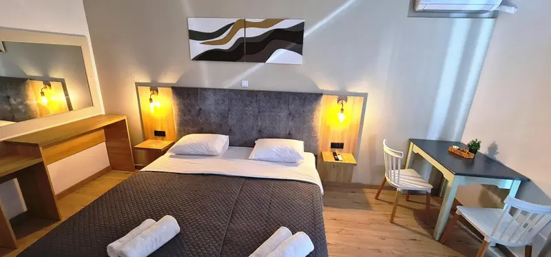 Une chambre avec un lit double et un bureau.