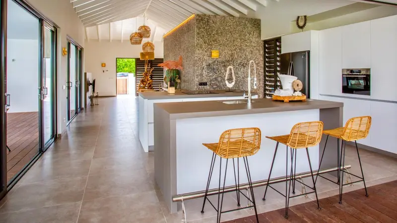 Une cuisine moderne et lumineuse s'ouvre sur un espace de vie spacieux.