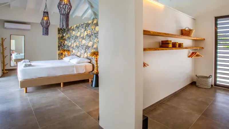 Une chambre lumineuse avec un lit et un espace rangement ouvert.
