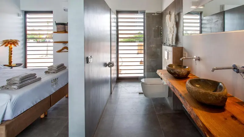 Une chambre lumineuse avec un lit et une salle de bain moderne.
