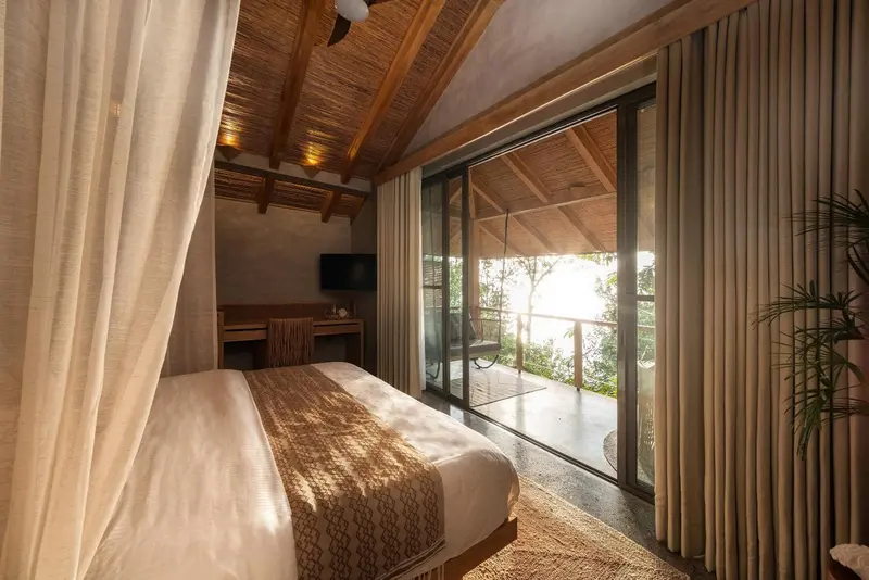 Une chambre lumineuse avec un grand lit et un accès à une terrasse.