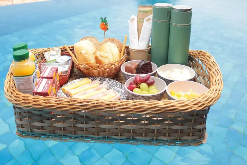 Un plateau de petit-déjeuner est présenté sur le bord d'une piscine.