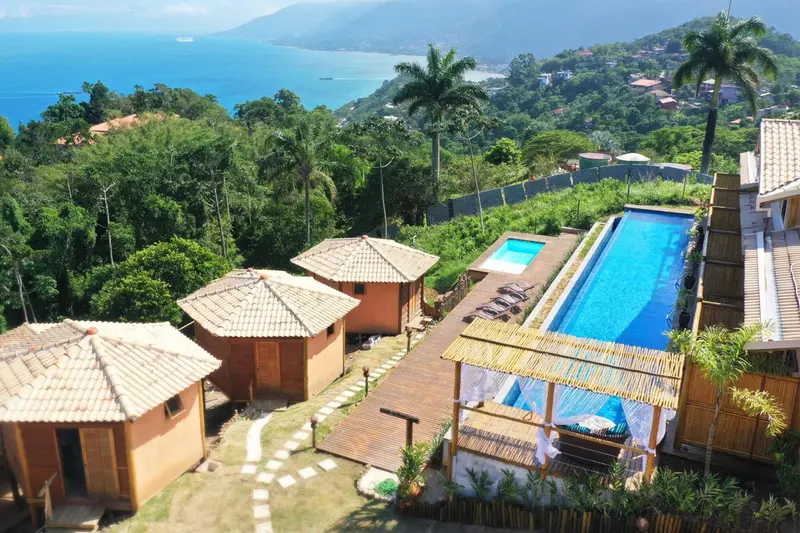Vue aérienne d'un complexe hôtelier avec piscine et végétation luxuriante.