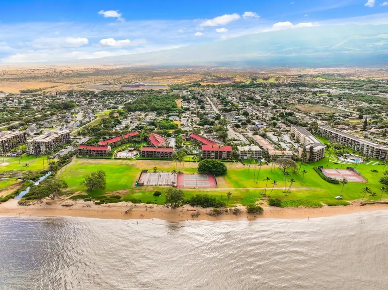 Vue aérienne d'un complexe hôtelier bordant une plage de sable fin.