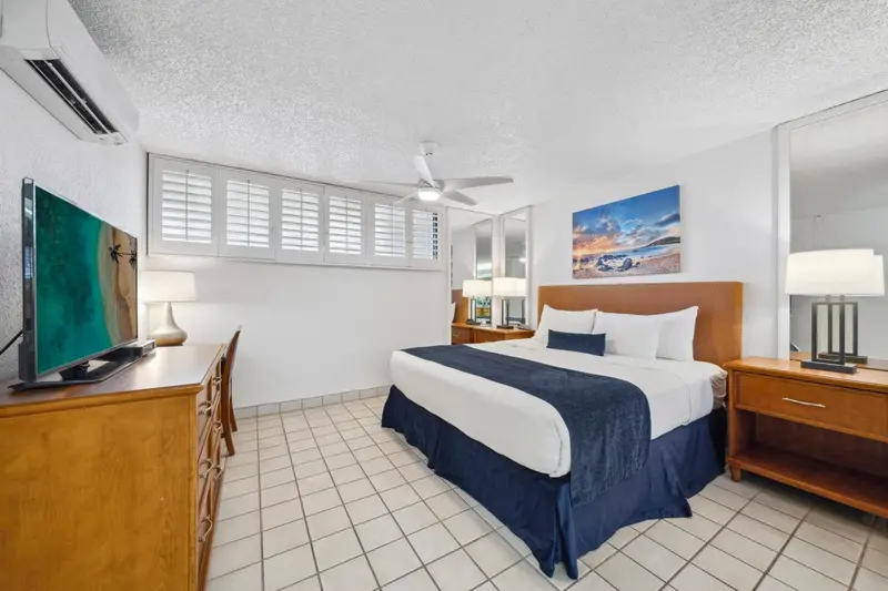 Une chambre lumineuse avec un grand lit et une télévision à écran plat.